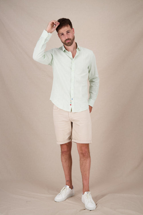 A fish named Fred - Shirt stripe linen - Men's light green striped linen shirt from A Fish Named Fred styled with beige shorts and white sneakers, showcasing.