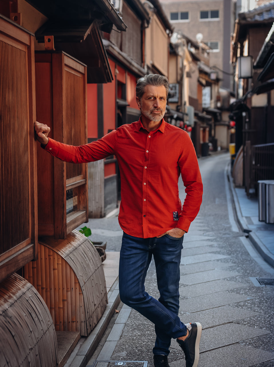 A Fish Named Fred men's Corduroy shirt in Red, worn by a model in a traditional wooden alley