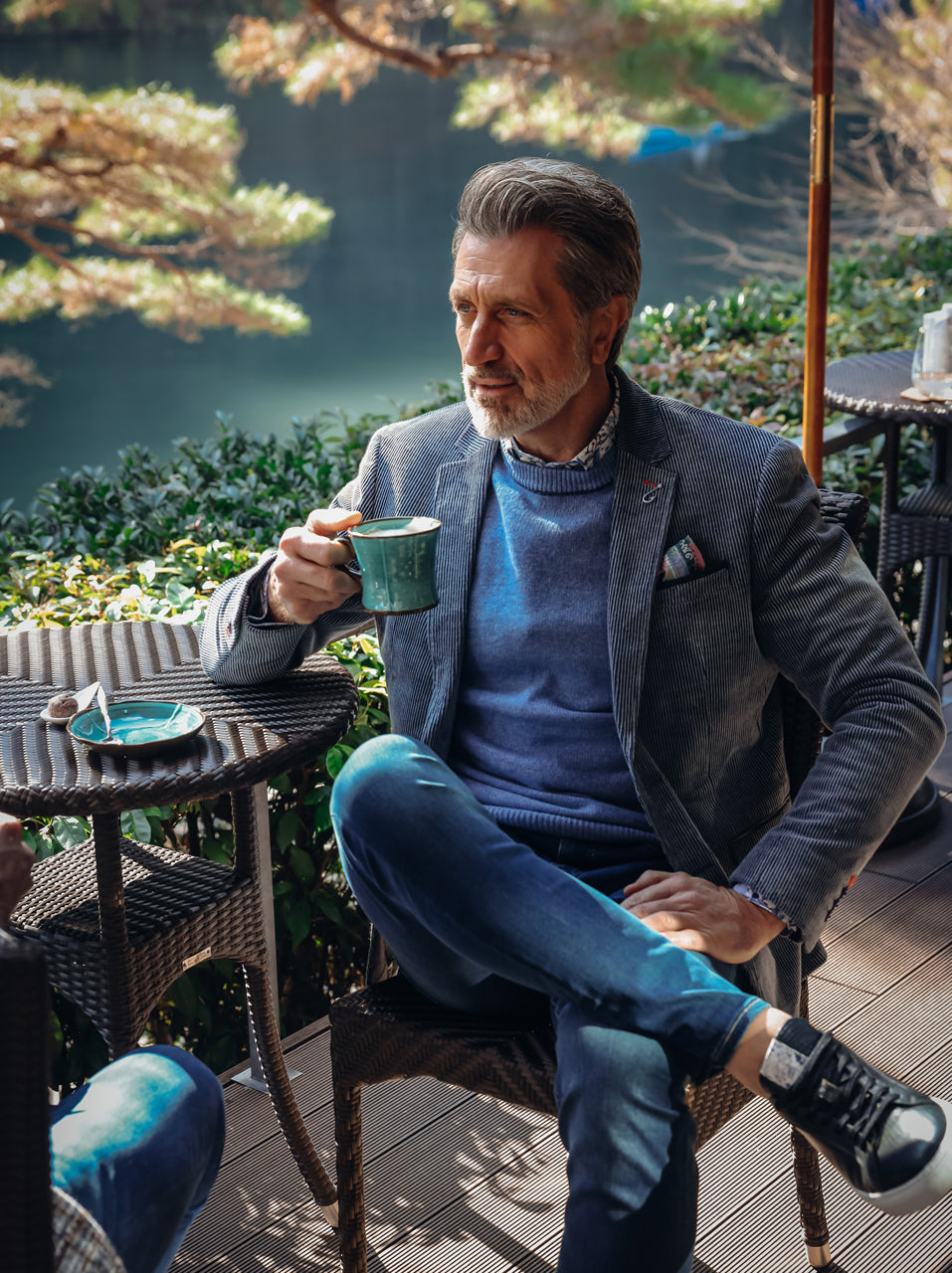 A Fish Named Fred men's Two Tone Rib blazer in Jeans Blue, worn by a model at a garden cafe table