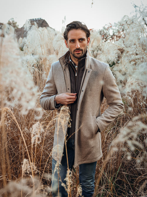 A Fish Named Fred men's Funnel Neck Coat in Sand, worn by a model, outdoor lifestyle shot