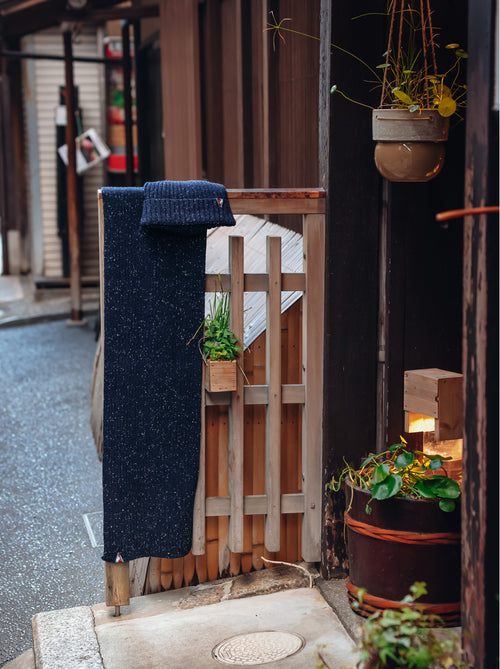 A Fish Named Fred men's Knitted scarf in Navy, hanging outside a traditional shop