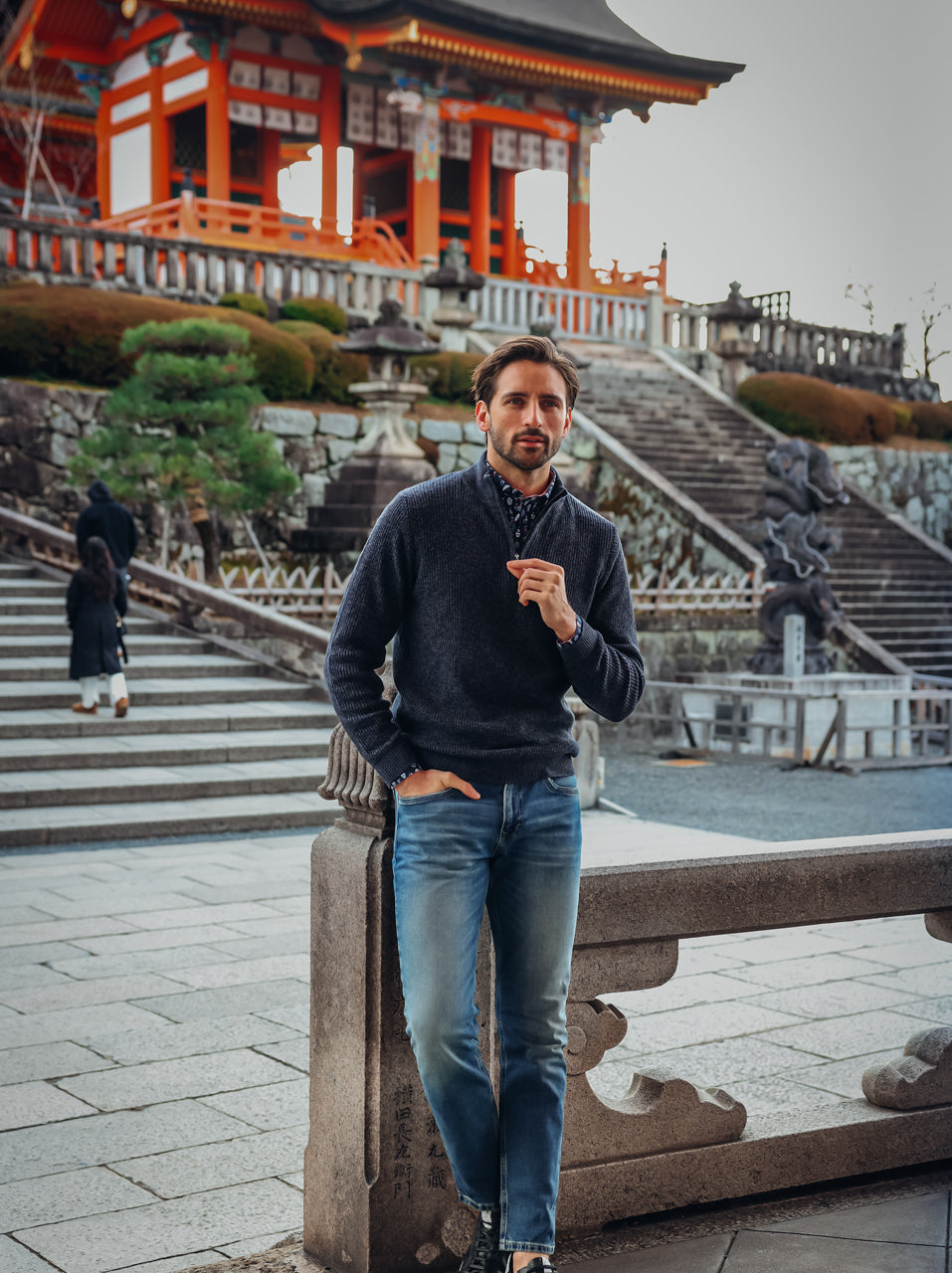 A Fish Named Fred men's Mock-zip pullover in Navy, worn by a model on a temple terrace